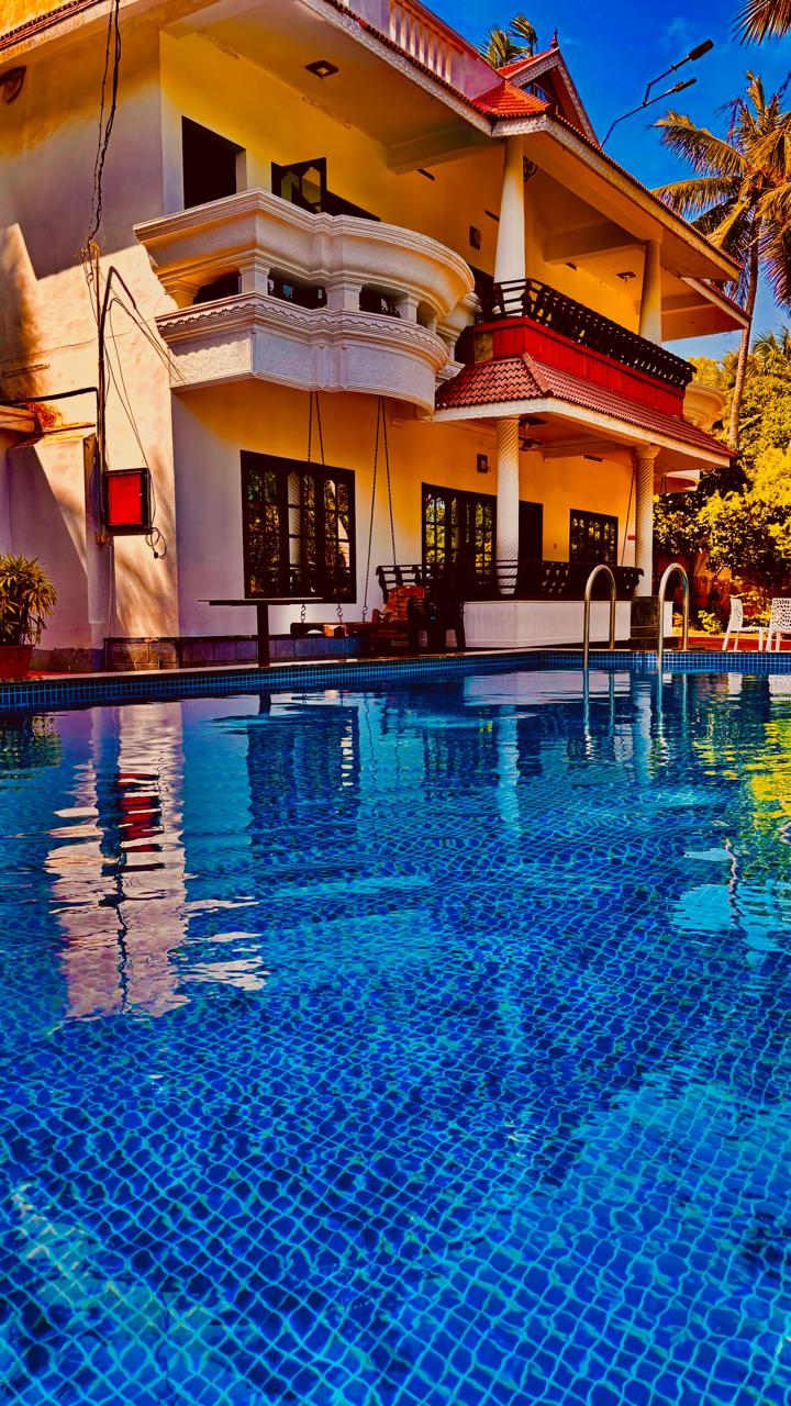 Blue swimming pool beneath the guest house balconies