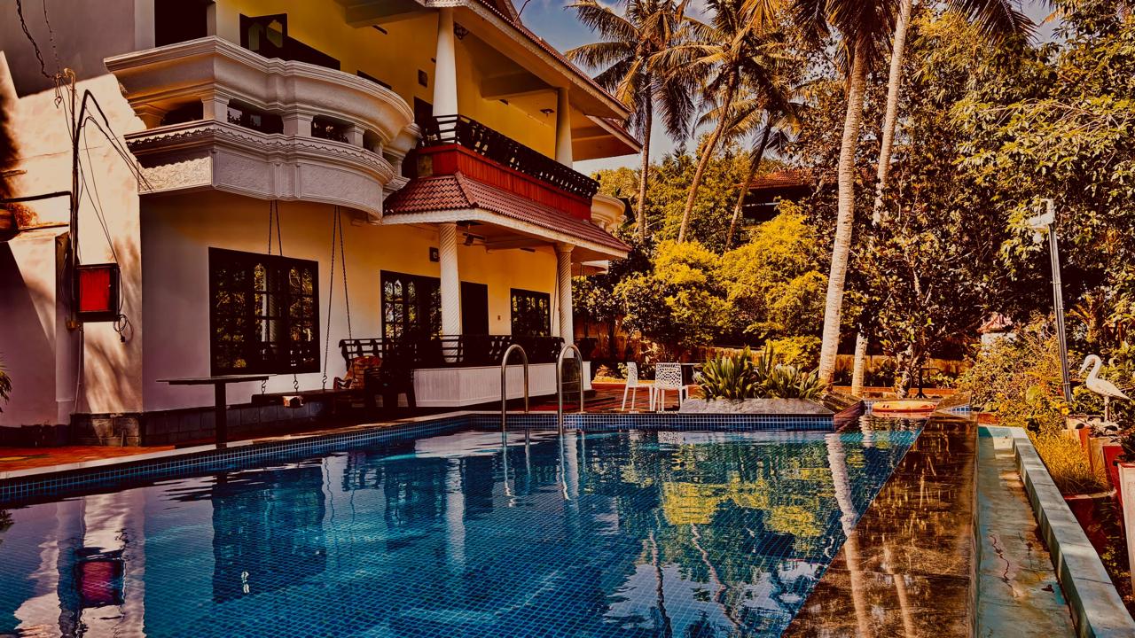 Whispering Kera homestay and swimming pool surrounded by tropical palms in Poovar