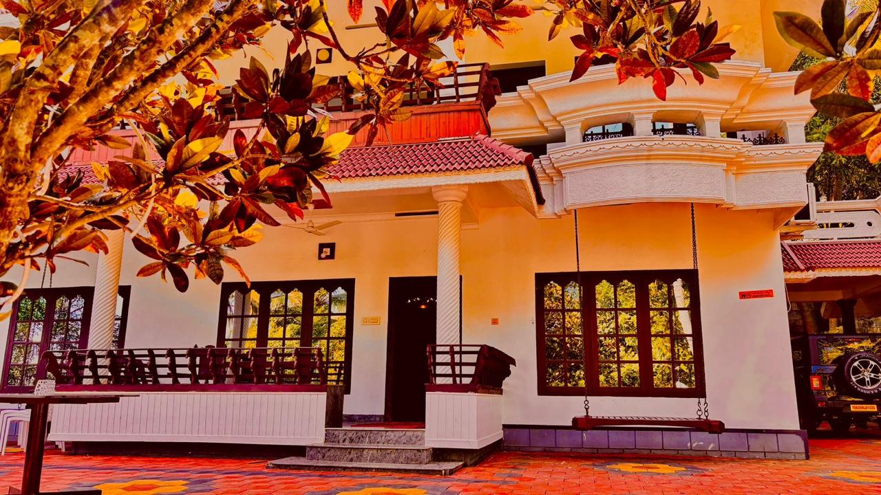 Shaded verandah and traditional swing at Whispering Kera homestay in Poovar