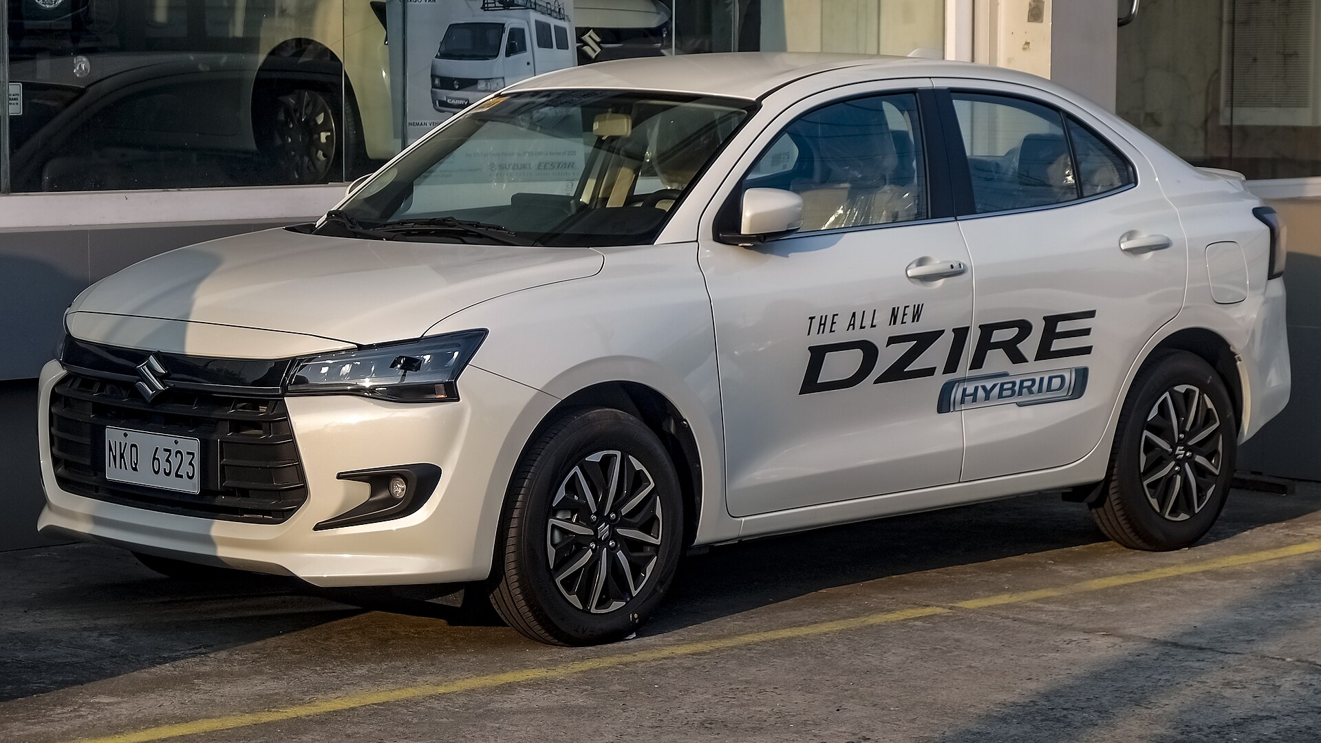 White Suzuki Dzire representative of the five-seater AC sedan fleet